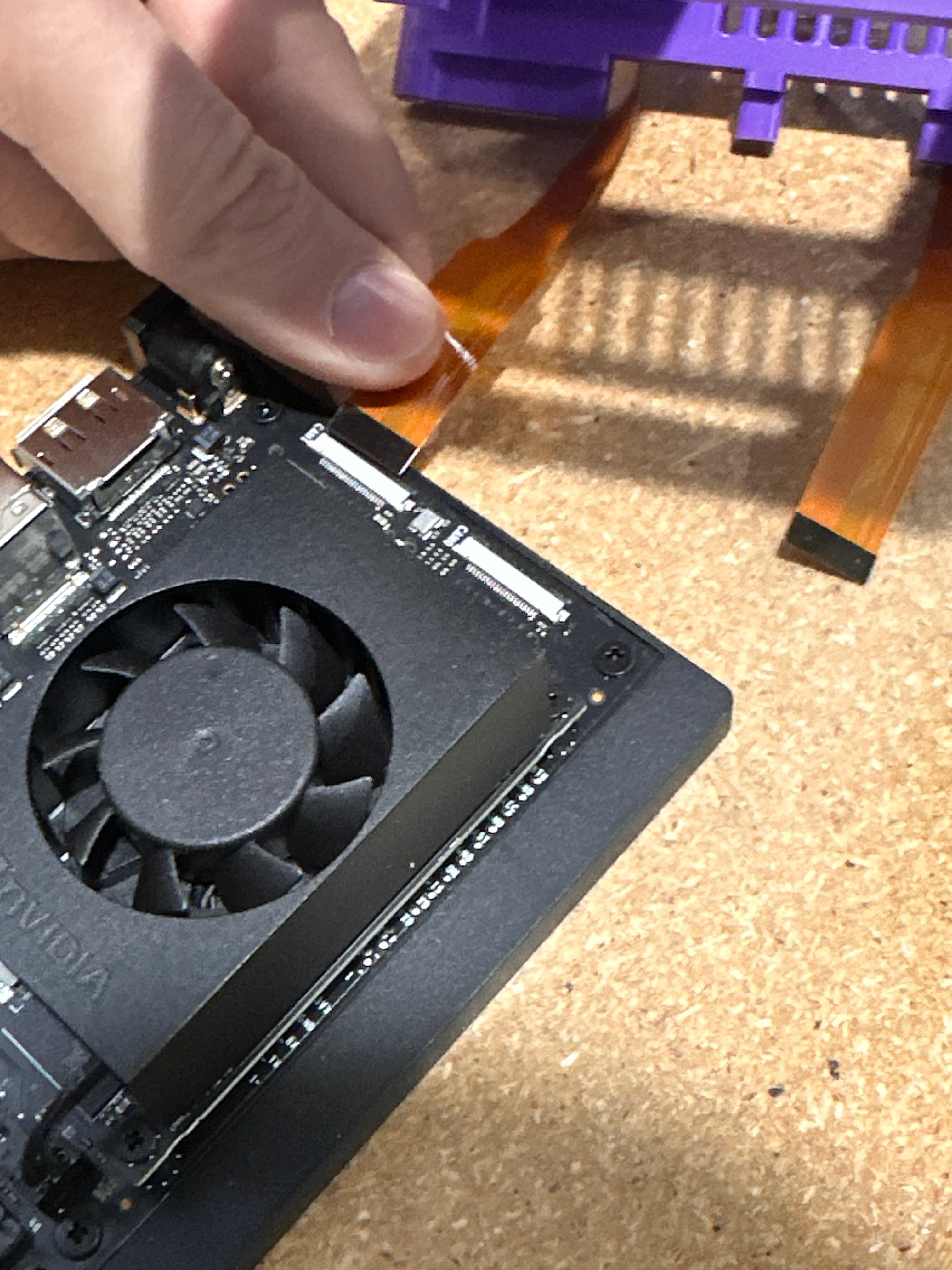 Inserting a CSI ribbon cable into the CAM1 connector on the Jetson Orin Nano